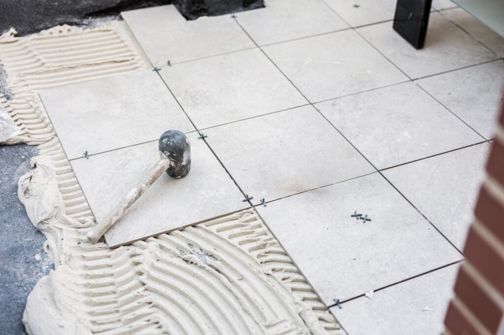Tiler placing the ceramic tile on the floor. Grouting ceramic tiles. renewal. Construction.